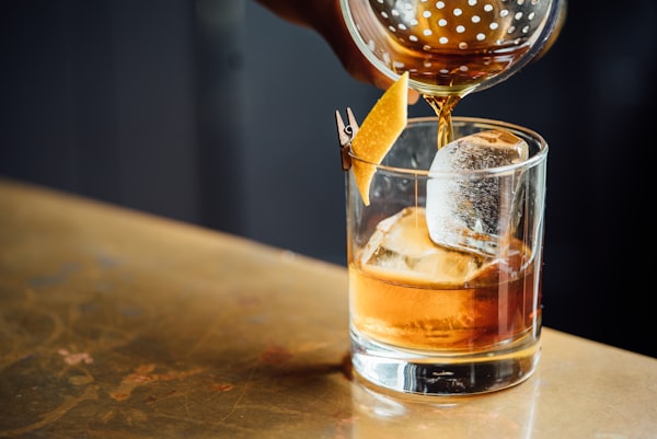 Elixir d'Anvers served on the rocks with orange zest in an old-fashioned glass
